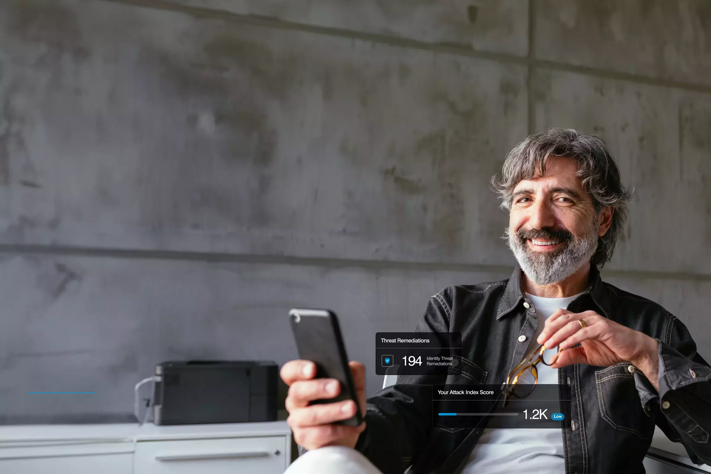 Bearded man with mobile phone sitting smiling